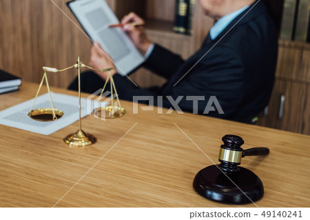 Gavel on wooden table and Lawyer or Judge working with agreement 49140241