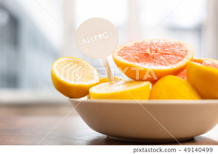 Lemons and grapefruits in little white bowl standing near window Lemons and grapefruits in little white bowl standing near window 49140499