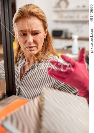 Dark-eyed housewife having allergic reaction to dust at home Dark-eyed housewife having allergic reaction to dust at home 49140690