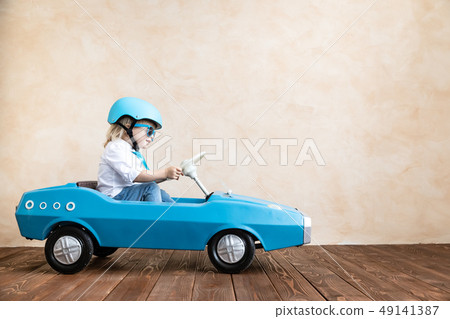 Funny kid driving toy car at home 49141387