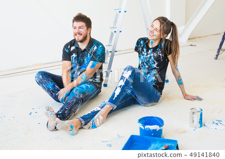 Renovation, redecoration and people concept - young couple doing a renovation in new home and have Renovation, redecoration and people concept - young couple doing a renovation in new home and have 49141840