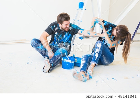 People, renovation and interiors concept - Young couple sitting on the white floor and have fun at 49141841