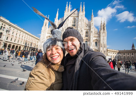Couple taking self portrait with pigeon in Duomo square in Milan. Winter traveling, Italy and Couple taking self portrait with pigeon in Duomo square in Milan. Winter traveling, Italy and 49141999