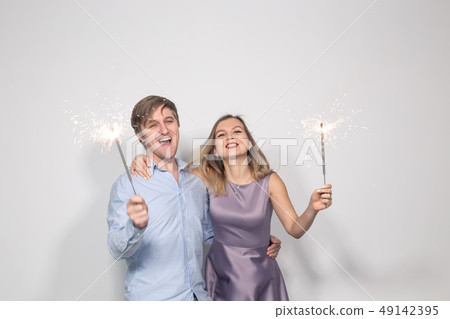 Party, family and holidays concept - young couple celebrating their anniversary with sparklers on Party, family and holidays concept - young couple celebrating their anniversary with sparklers on 49142395