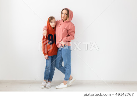Mothers day, children and family concept - teen boy hugging his mom on white background with copy Mothers day, children and family concept - teen boy hugging his mom on white background with copy 49142767