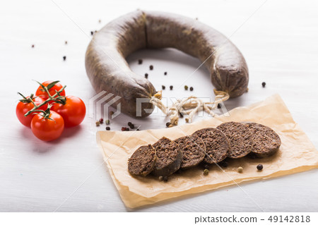 Food, meat and delicious concept - sausages made with horse meat with tomatoes on table Food, meat and delicious concept - sausages made with horse meat with tomatoes on table 49142818