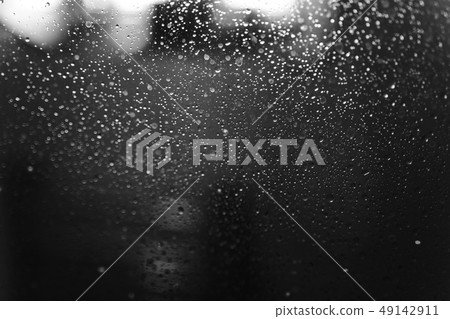 Closeup of condensation patterns on glass window, water droplets with light reflection and 49142911