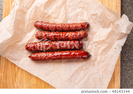 food, delicious and serving concept - grilled sausages on wooden board food, delicious and serving concept - grilled sausages on wooden board 49143144