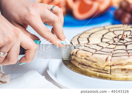Woman's hands cut whole esterhazy torte cake with knife. Authentic recipe, hungarian and austrian 49143326