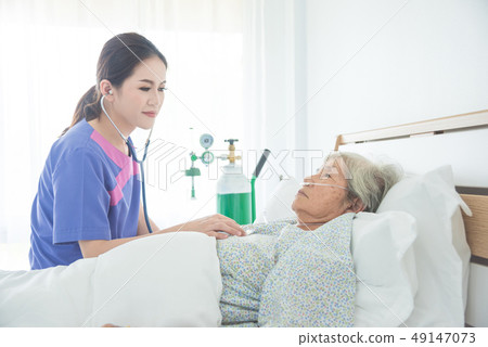 Senior patient lying in bed while doctor exam Senior patient lying in bed while doctor exam 49147073