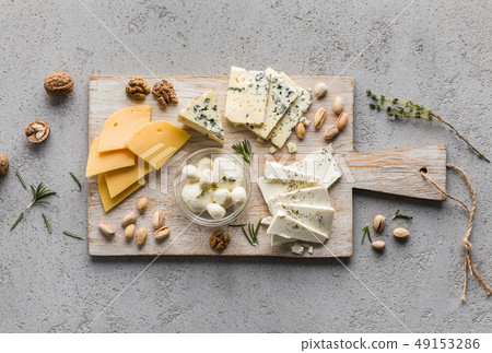 Assortment of cheese with nuts on wooden board 49153286