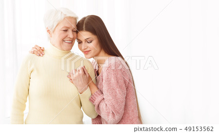 Loving woman embracing mum, posing for family photo 49153562