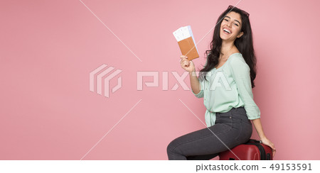 Happy woman with passport sitting on suitcase Happy woman with passport sitting on suitcase 49153591
