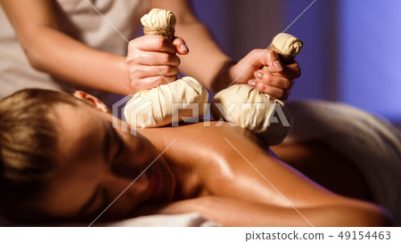 Oriental therapy salon. Woman having herbal massage Oriental therapy salon. Woman having herbal massage 49154463