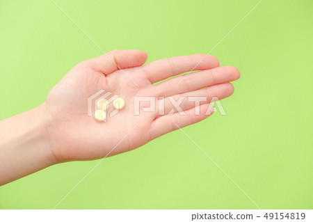 Stock Photo: hand holding a pill drug treatment chronic fatigue 49154819
