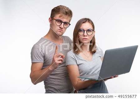 Nerds, study, people concept - a couple of student people look with laptop look like they are Nerds, study, people concept - a couple of student people look with laptop look like they are 49155677