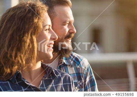Happy couple looking aside and smiling, walking in city 49155698