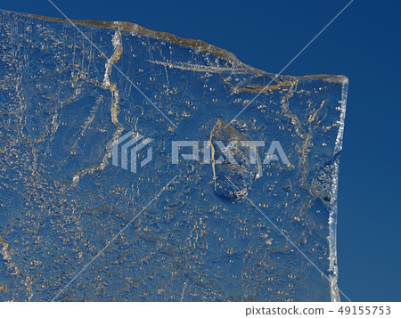 Sun rays caught in cracks in ice piece. Broken 49155753
