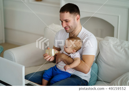 father feeding his little son from bottle 49159552