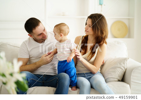 mother, father and little son in living room mother, father and little son in living room 49159901