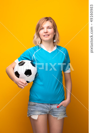Photo of blonde with soccer ball on yellow background Photo of blonde with soccer ball on yellow background 49160983