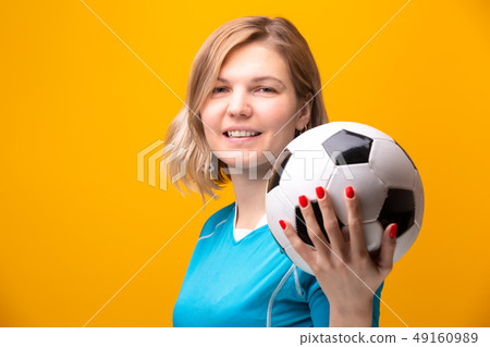 Photo of blonde with soccer ball on yellow background Photo of blonde with soccer ball on yellow background 49160989