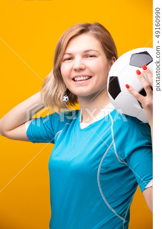 Photo of blonde with soccer ball on yellow background 49160990