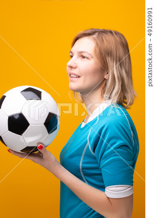 Photo of blonde with soccer ball on yellow background 49160991