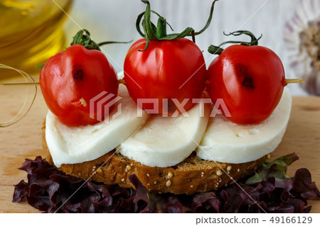 Bruschetta with mozzarella and cherry tomatoes Bruschetta with mozzarella and cherry tomatoes 49166129