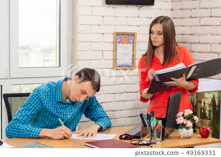 The secretary signs documents with the head The secretary signs documents with the head 49169331