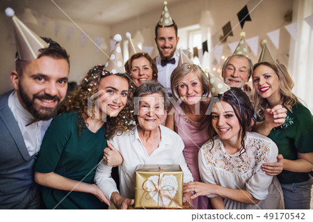 A portrait of multigeneration family with presents on a indoor birthday party. 49170542