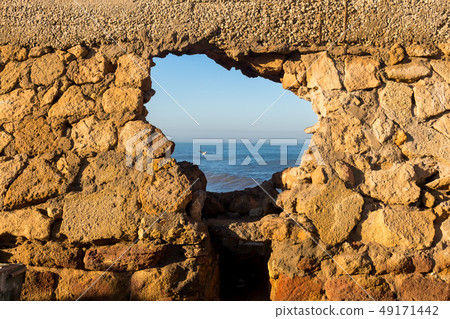 Stone wall with a hole and Atlantic ocean Stone wall with a hole and Atlantic ocean 49171442