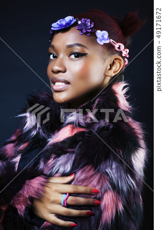 young pretty african american woman in spotted fur coat and flowers jewelry on black background young pretty african american woman in spotted fur coat and flowers jewelry on black background 49171672
