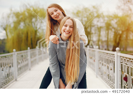 two pretty sisters in a park two pretty sisters in a park 49172040