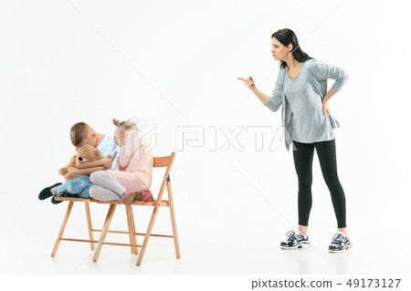 Angry mother scolding her son in living room at home Angry mother scolding her son in living room at home 49173127