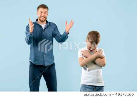 Angry father scolding his son in living room at home Angry father scolding his son in living room at home 49173160