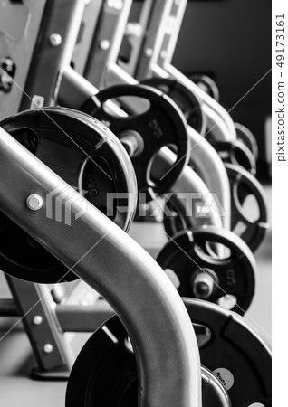 Modern gym interior with bench press equipment in a raw Modern gym interior with bench press equipment in a raw 49173161