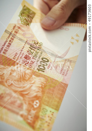 Male hand holding Hong Kong dollar banknote Male hand holding Hong Kong dollar banknote 49173603