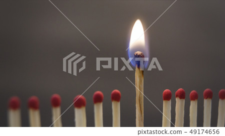 One burning match between spoiled ones on black 49174656