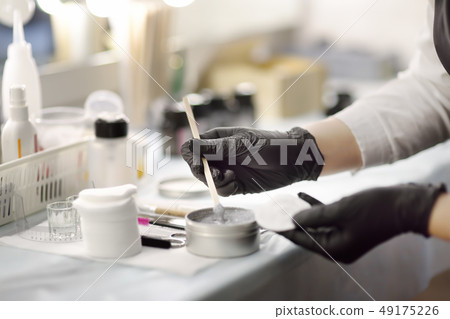 Beautician stirs the scrub and prepares it for use 49175226
