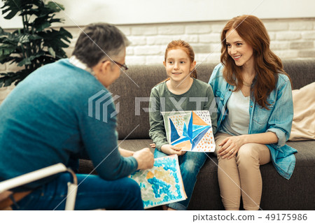 Delighted positive girl showing a painting to the doctor 49175986