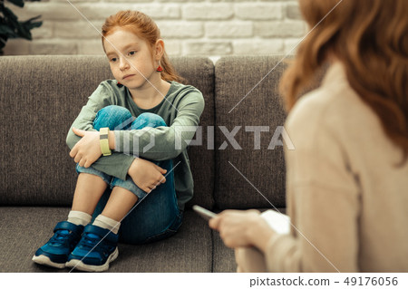 Sad cheerless girl sitting on the sofa 49176056