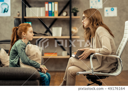 Pleasant professional psychologist speaking to her patient Pleasant professional psychologist speaking to her patient 49176164
