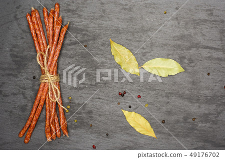 Spicy tyrolini salami stick on grey stone 49176702