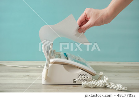 一個人從傳真機上取紙。從傳真機發送紙張的人 49177852