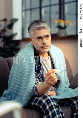 Sad cheerless man thinking about his illness 49179425
