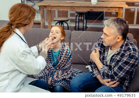 Cute red haired girl sitting in front of the doctor 49179635