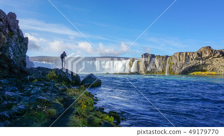 A tourist enjoy viewing at Godafoss waterfalls 49179770