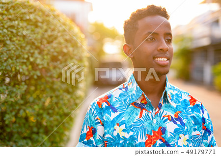 Face of happy young African tourist man thinking outdoors 49179771