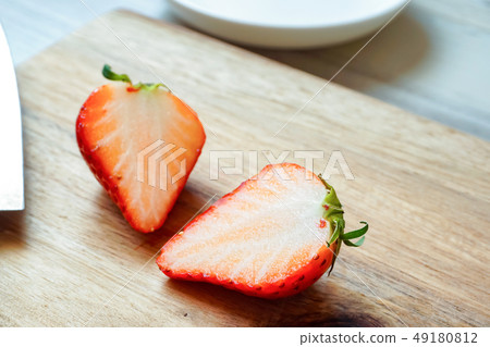 Half cut strawberry on cutting board Half cut strawberry on cutting board 49180812
